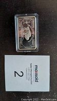 Top view of one silver bar with a bison and text 'UNITED STATES OF AMERICA' and '1 TROY OZ' in a clear plastic case.