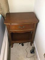 Front angle view of one bedside table showing drawer and lower shelf