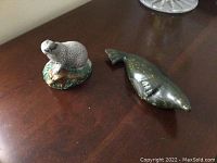 Photo of ceramic Beswick badger figurine and dark green soapstone seal carving on a wooden table