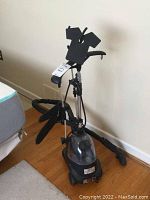 Full view of the SteamOne portable clothing steamer showing base unit with water tank, adjustable pole and garment hangers.