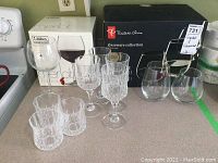 Photo showing the boxed Libbey Vineyard merlot glasses along with the boxed Presidents Choice stemless wine glasses, and unboxed crystal wine and juice glasses.