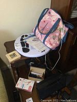 Full lot overview including Dr Ho circulation promoter, tote bag, coasters, headphones, earbuds, Sharper Image speaker with remote.
