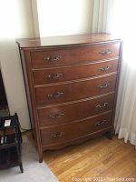 Full frontal view of the Malcom wooden dresser with five drawers and decorative metal handles, providing a general sense of style and condition.