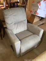 Full front view of the beige La-Z-Boy recliner showing cushioned back and fabric upholstery with wear on arms.