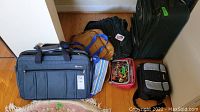 Photo showing variety of travel bags and lunch bags including soft luggage, reusable bag, and insulated lunch bags.