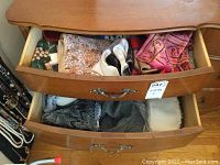 Dresser drawers with a variety of scarves in mixed materials and gloves visible in the top drawer, and wool scarves or shawls in the second drawer.