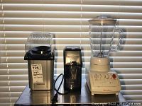 Photo of three small appliances: Toastess popcorn popper on left, Black and Decker coffee grinder in middle, Moulinex blender on right.