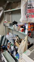 Photo showing metal framed utility shelf loaded with various household items including small containers, cleaning supplies, tapes, and miscellaneous.