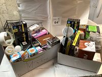 Two boxes filled with various new boxed light bulbs including LED and halogen bulbs by Philips, NOMA, GE, and DFL, assorted sizes and shapes.