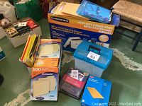 Overview of boxed bankers box, file folders, and plastic file carry case on floor near chairs