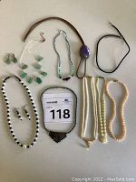 Full lot showing multiple beaded necklaces and pair of earrings.