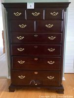 Front view of tallboy dresser showing all drawers, hardware, finish and carved details