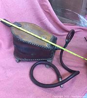Antique dentist power bellows showing top and side, leather body with metal rivets, tape measure for scale.