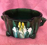 Front view of the planter showing detailed hand-incised floral decoration and lion head figure feet and handle.