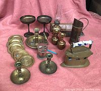 Full view of the lot showing all brass items arranged on a pink fabric background.