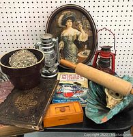Photo showing overview of all items including the Pepsi tray, ceramic planter with metal decoration, rolling pin, lanterns, books, and small wooden box.