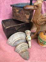 Photo showing wooden boxes, granite coffee pot, carved bottle stopper, wooden rooster, and architectural moldings.