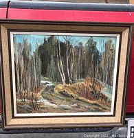 Framed oil painting showing a landscape with trees and water rapids, signed by Norah Hiscock.