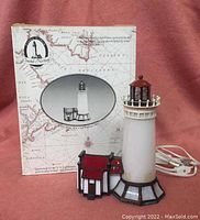 Full view of stained glass lighthouse desk lamp with original box.