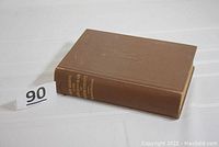 Full book side view showing brown buckram cloth binding and gilt spine text.