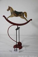 Front view of the decorative balancing rocking horse pendulum toy showing horse, base, and pendulum.