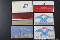 Eight coin sets in original packaging including four uncirculated sets from different years and two Americana Series presidents collection sets.