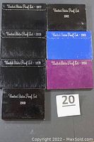 Overview of all seven U.S. proof coin sets in original packaging, with year labels visible.