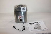 Front view of the stainless steel ice cream maker with power cord and user manual