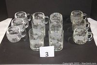 Full set layout showing six mugs, four tumblers, sugar container with lid, and creamer, all decorated with etched world map design.