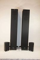 Front view of two tower speakers with two satellite speakers visible