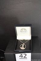 Puffin pendant displayed in black Shetland Jewellery box, showing pendant and chain against black backdrop.