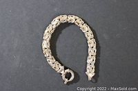 Full view of the silver Byzantine chain bracelet laid flat against a black background, showing the clasp and thickness of the bracelet.