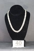Full view of necklace draped on black bust with lot number sign
