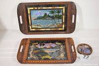 Three reverse paintings on glass displayed: Two rectangular serving trays with Rio de Janeiro scenes, and one round portrait in inlay frame.