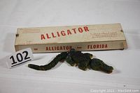 Toy alligator with original mailing box, showing overall length and segmented tail detail.