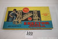 Closed original box with artwork showing child playing and assembled wooden models, labeled Erector Junior Wood Construction Set