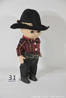 Front view of doll wearing outfit and hat