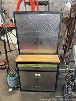 Front view of stacked cabinets showing lower wood-topped unit and upper diamond-plate cabinet