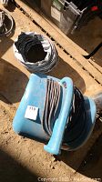 Top and side view showing the blue Drieaz Sahara Power Dryer with coiled power cord and attached flexible Thermaflex tunnel.