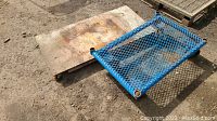 View of both wooden and metal flat rolling carts side by side on dirt ground showing overall wear and condition.