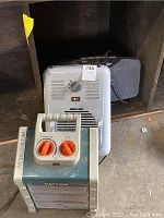 Three heaters stacked with Patton heater in front showing control knobs and metal mesh front.