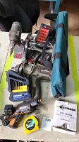 Wide shot showing the Bosch drill, Maximum Impact Wrench, Mastercraft drill bit set, Komelon measuring tape, Worx rotary tool, charger, and Bosch tool bag.