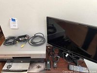 Samsung TV, Sony DVD/VHS combo player, TiVo unit with cables and remotes displayed on a table.