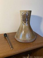 Close-up image of ceramic vase with Native American style painted design, showing surface and form details.
