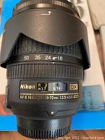 Close-up photo of Nikon AF-S Nikkor 18-70mm lens from side showing focusing and zoom rings with Nikon and DX labels