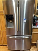 Front view of stainless steel French door refrigerator with water and ice dispenser