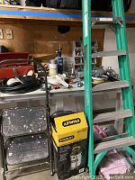 Wet/Dry Vacuum in original Stanley box next to metal step stool and Werner ladder