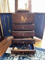 Full view of open wood jewelry case showing doors, drawers and contents