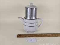 Front and side view of the ceramic and metal drip coffee maker next to a ruler for size reference.