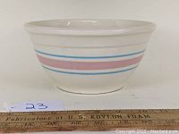 Side view of McCoy Pottery ovenproof mixing bowl showing the pink wide band and two thin blue bands around the bowl.